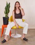 Allison is sitting in a yellow and white chair wearing Work Pants in Vintage Tee Off-White and an espresso brown Tank Top