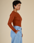 Side view of Mika in the Burnt Terracotta Long Sleeve Baby Tee