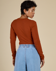 Back view of Mika in the Burnt Terracotta Long Sleeve Baby Tee