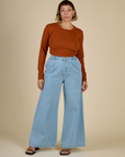 Tiara wearing the Burnt Terracotta Long Sleeve Baby Tee tucked into Light Wash Wide Leg Denim Trousers