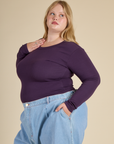 Angled side view of Juliet wearing the Nebula Long Sleeve Baby Tee