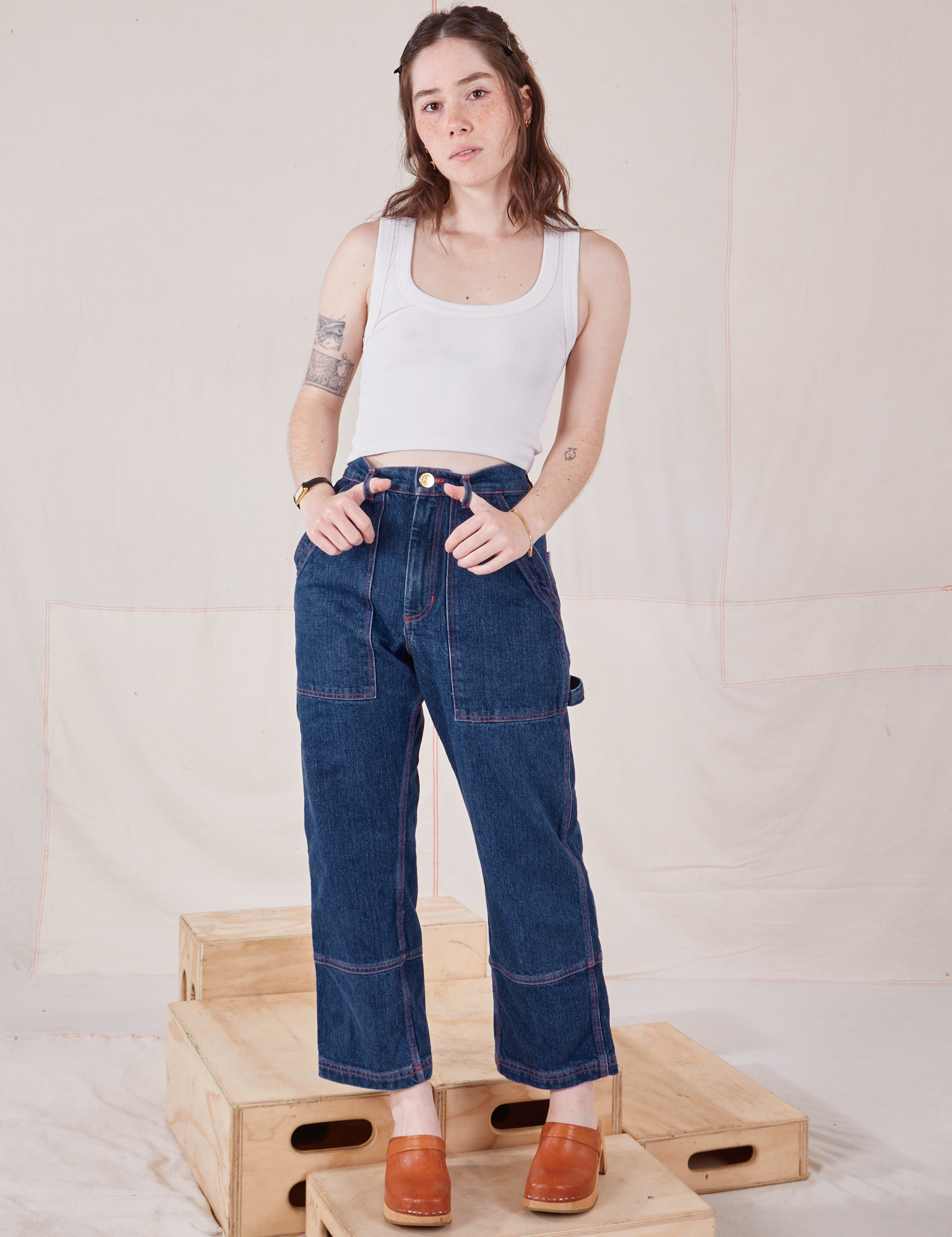 Hana is 5&#39;3&quot; and wearing XXS Petite Carpenter Jeans in Dark Wash paired with Cropped Tank Top in vintage tee off-white
