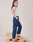Side view of Petite Carpenter Jeans in Dark Wash and Cropped Tank Top in vintage tee off-white on Hana