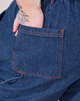 Petite Carpenter Jeans in Dark Wash back pocket close up. Jordan has their hand in the pocket.