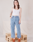 Hana is 5'3" and wearing XXS Petite Carpenter Jeans in Light Wash paired with Cropped Cami in vintage tee off-white
