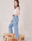 Side view of Petite Carpenter Jeans in Light Wash and Cropped Cami in vintage tee off-white on Hana