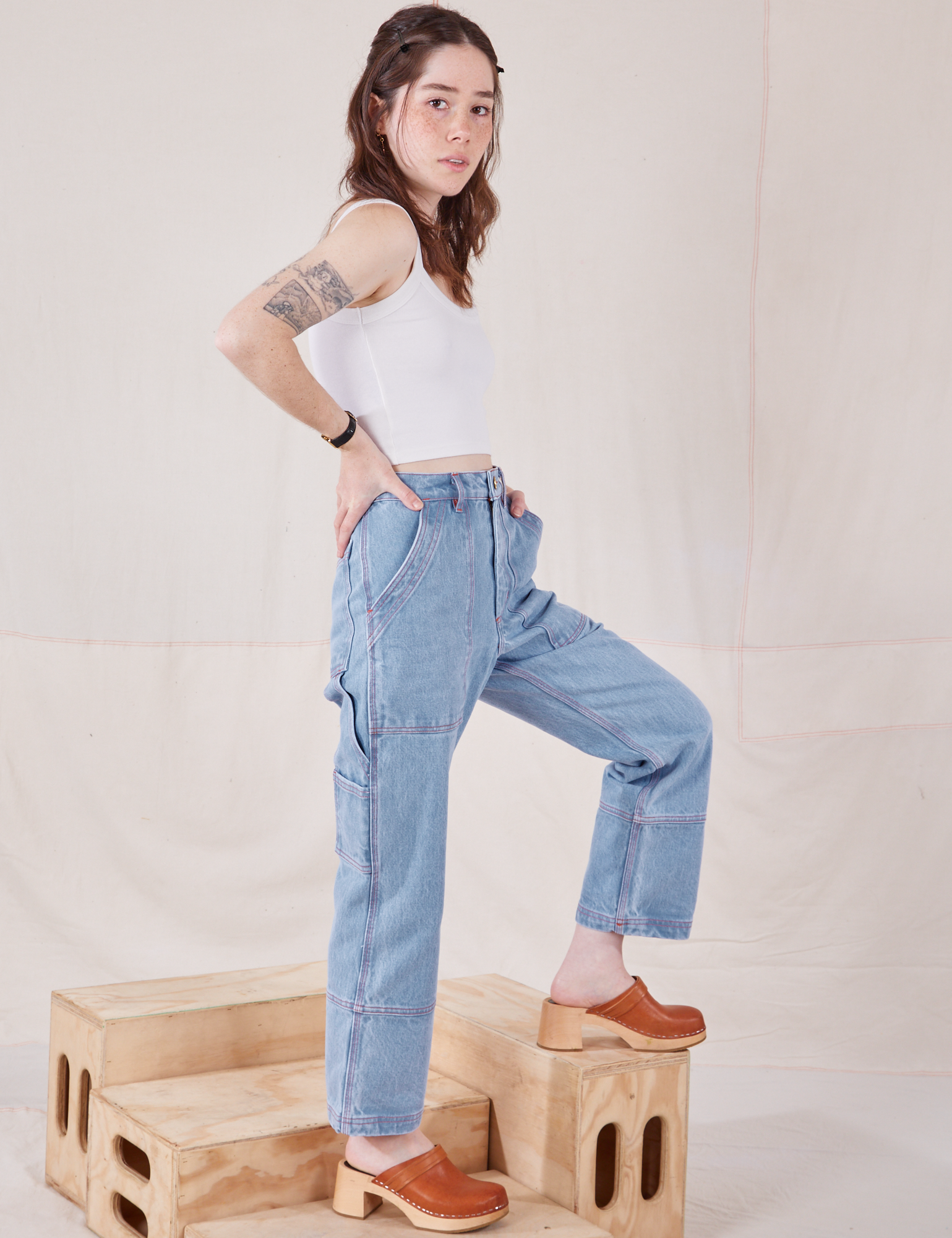 Side view of Petite Carpenter Jeans in Light Wash and Cropped Cami in vintage tee off-white on Hana