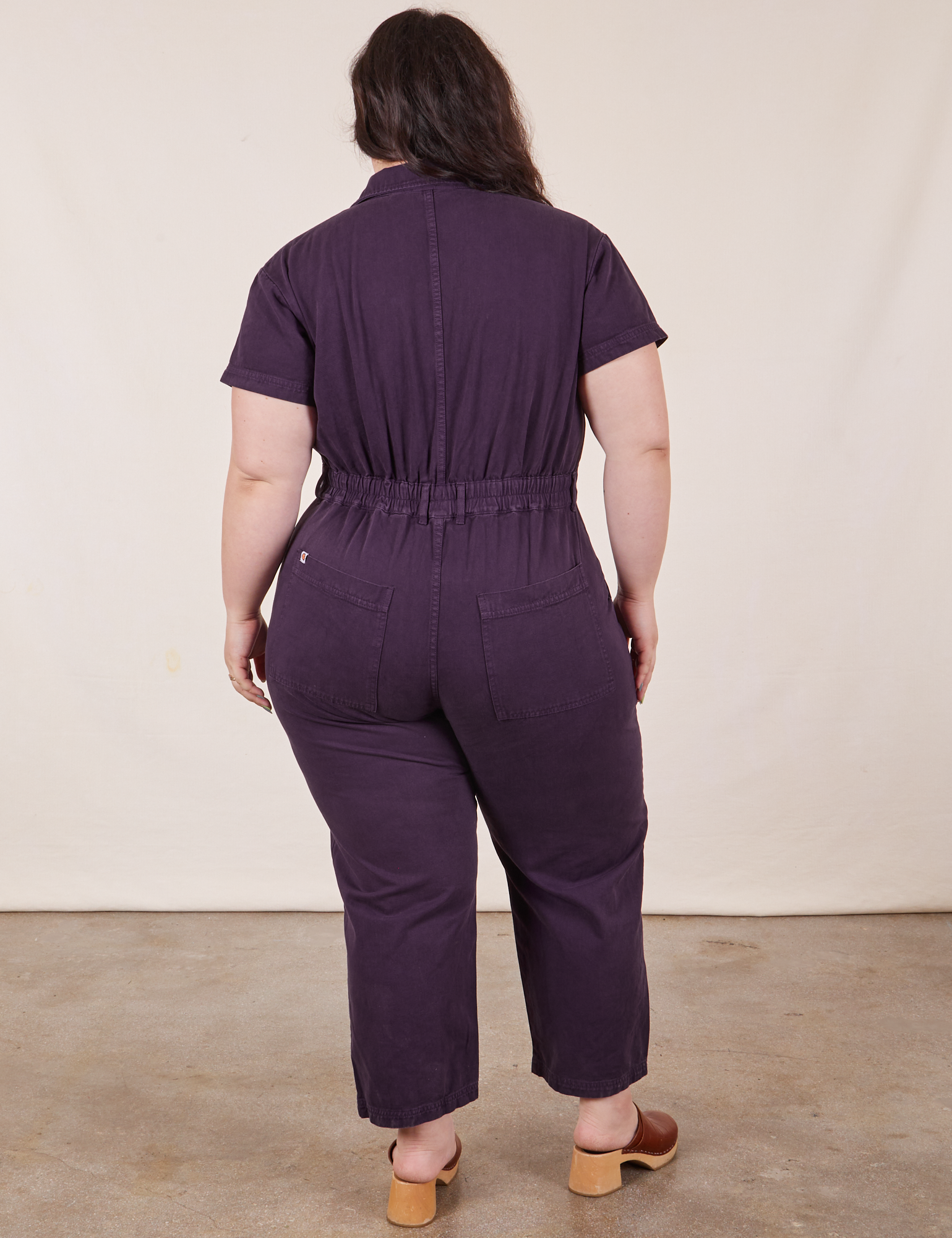 Back view of Petite Short Sleeve Jumpsuit in Nebula Purple worn by Ashley