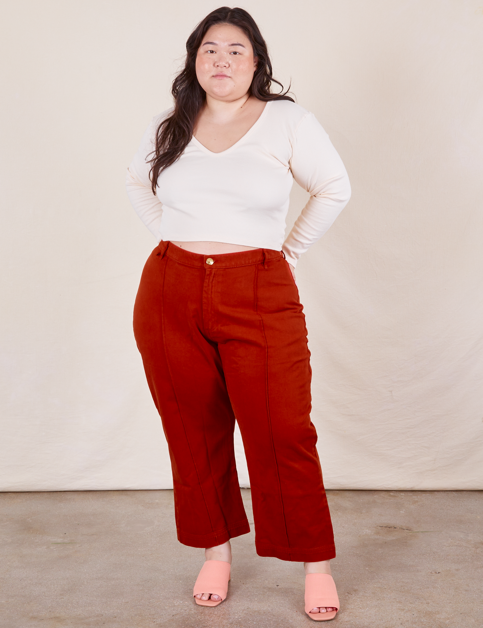 Ashley is 5&#39;7 and wearing 1XL Petite Western Pants in Paprika paired with a Long Sleeve V-Neck Tee in vintage tee off-white 