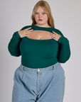 Juliet wearing the Hunter Green Long Sleeve Porthole Tee tucked in