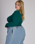 Side view of Juliet wearing the Hunter Green Long Sleeve Porthole Tee
