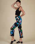 Side view of Alex in the Rainbow Magic Waters Work Pants and Black Cropped Tank