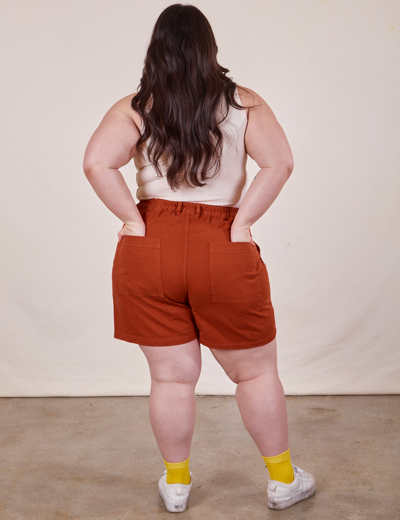 Back view of Classic Work Shorts in Paprika. Ashley has both hands in the back pockets.