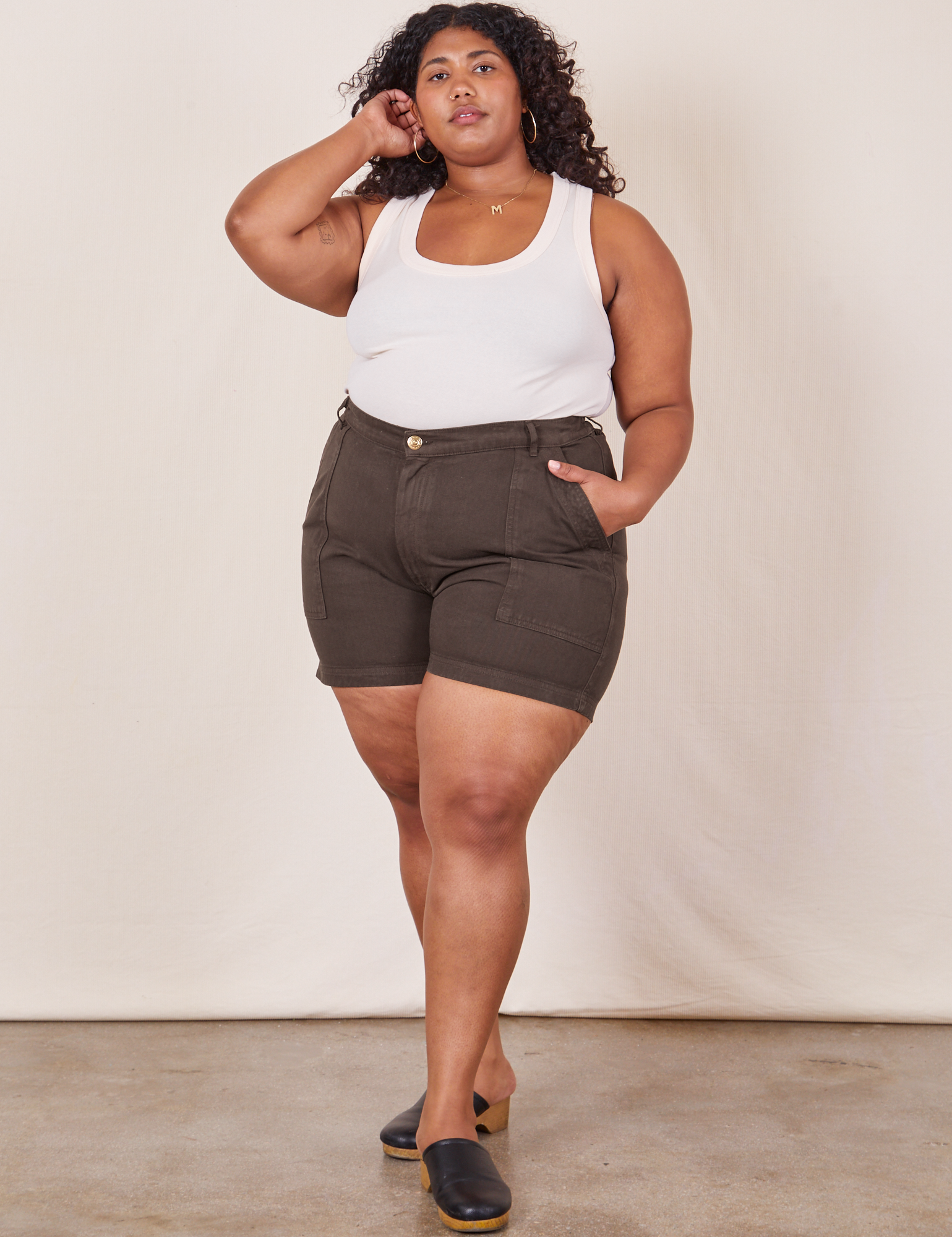 Morgan is 5’5” and wearing 1XL Classic Work Shorts in Espresso Brown paired with a Tank Top in vintage tee off-white
