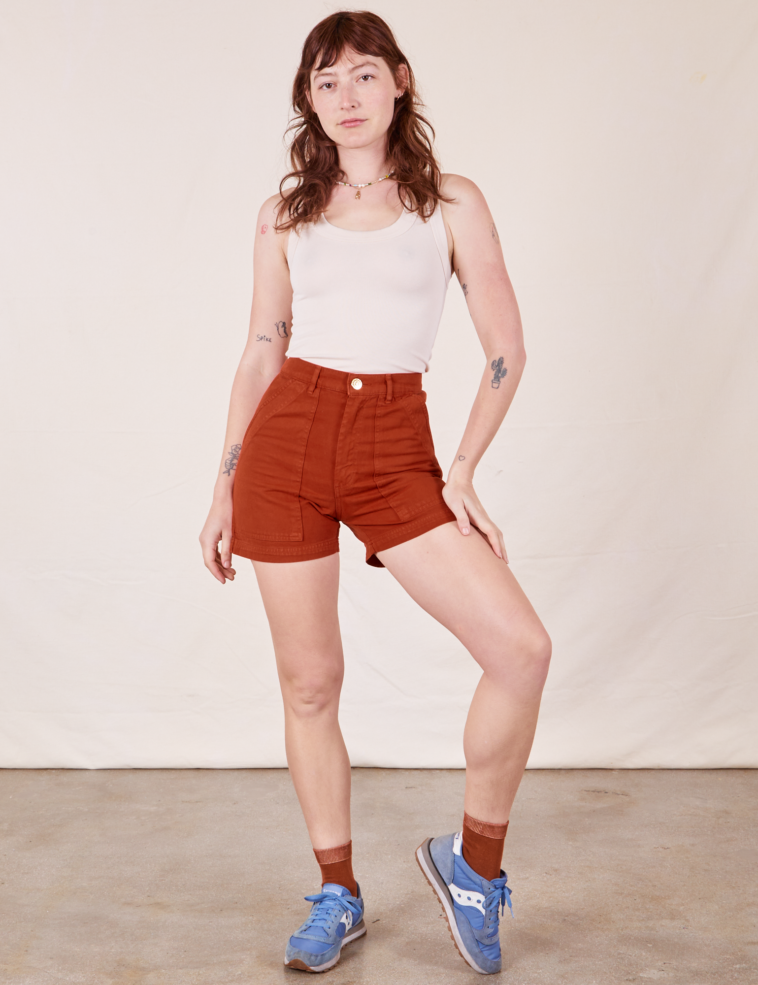 Alex is 5&#39;8&quot; and wearing XS Classic Work Shorts in Paprika paired with Tank Top in vintage tee off-white