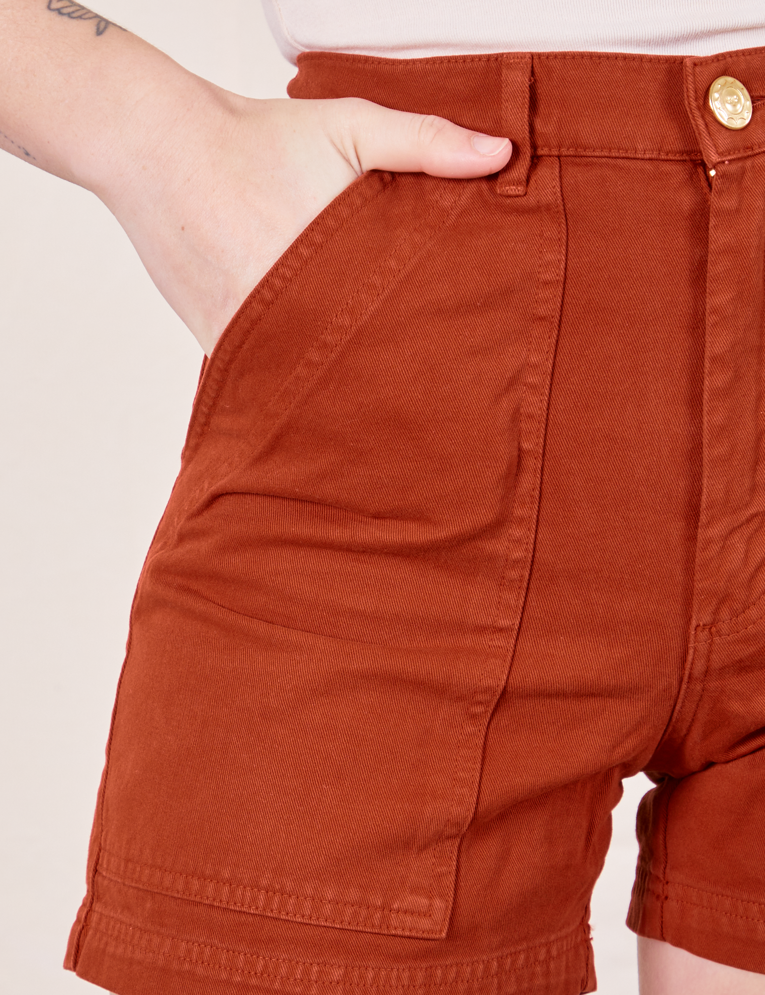 Classic Work Shorts in Paprika front pocket close up. Alex has her hand in the pocket.