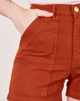 Classic Work Shorts in Paprika front pocket close up. Alex has her hand in the pocket.
