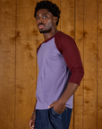 Side view of Isaac in the Faded Grape/Wine Colorblock Raglan Tee
