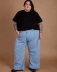 Sam is 5'10" and wearing 2XL Burly Tee in Basic Black paired with light wash Indigo Wide Leg Trousers