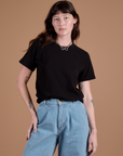 Alex is wearing Burly Tee in Basic Black tucked into light wash Indigo Wide Leg Trousers