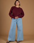 Tiara wearing the Red Wine Long Sleeve Burly Tee tucked into Light Wash Wide Leg Denim Trousers