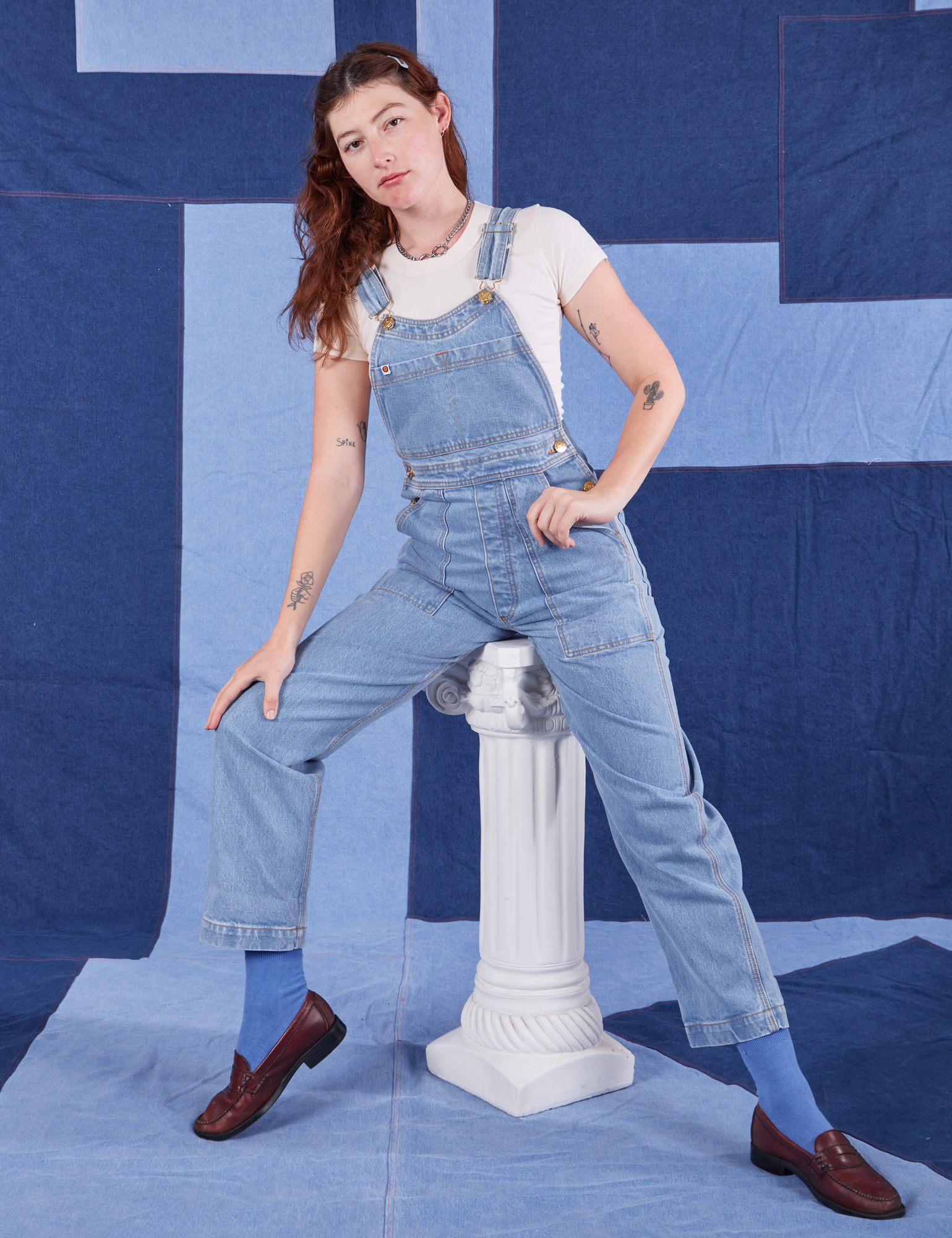 Alex is 5&#39;8&quot; and wearing P Indigo Denim Original Overalls in Light Wash with a vintage off-white Baby Tee underneath