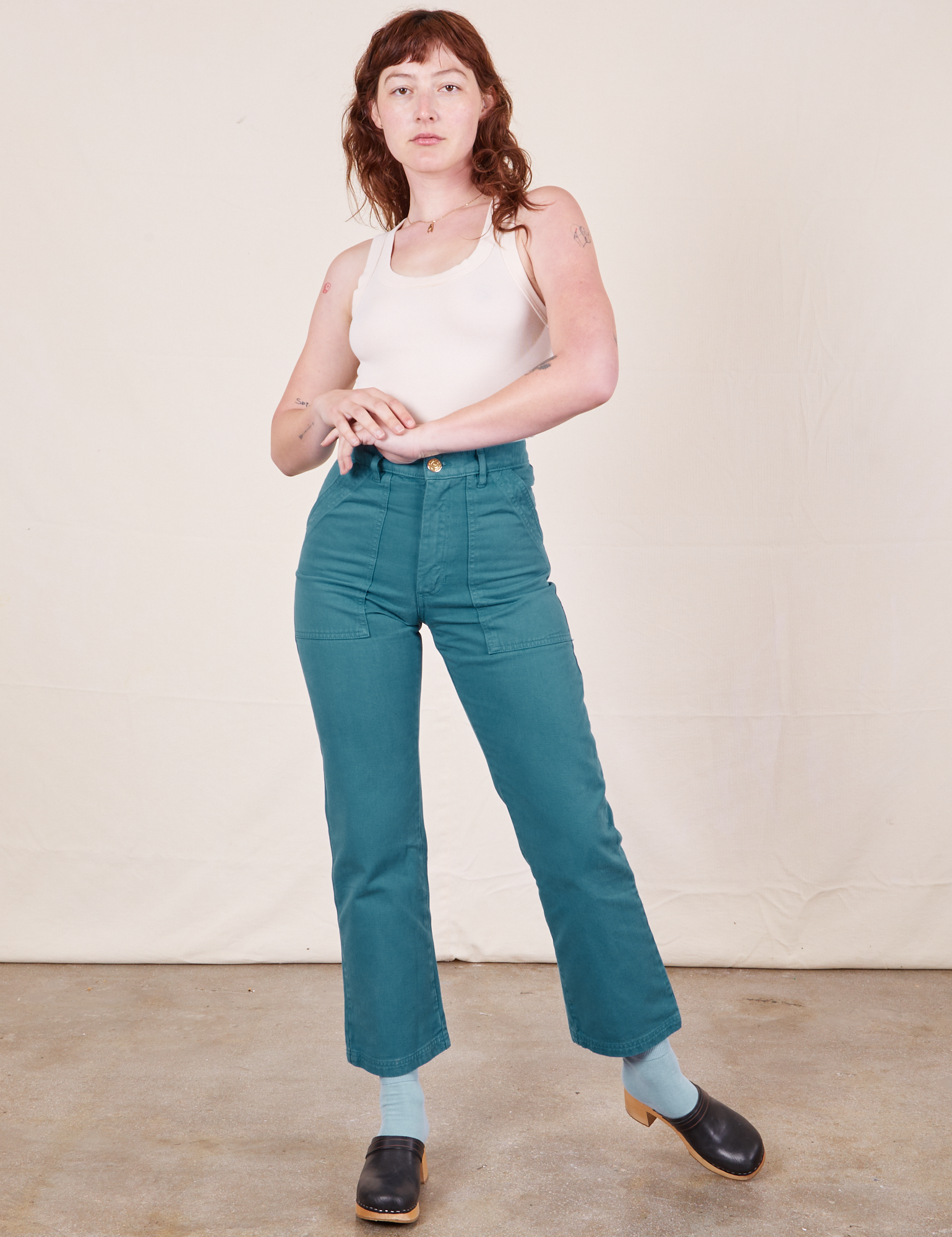 Alex is 5&#39;8&quot; and wearing XS Work Pants in Marine Blue paired with vintage off-white Tank Top