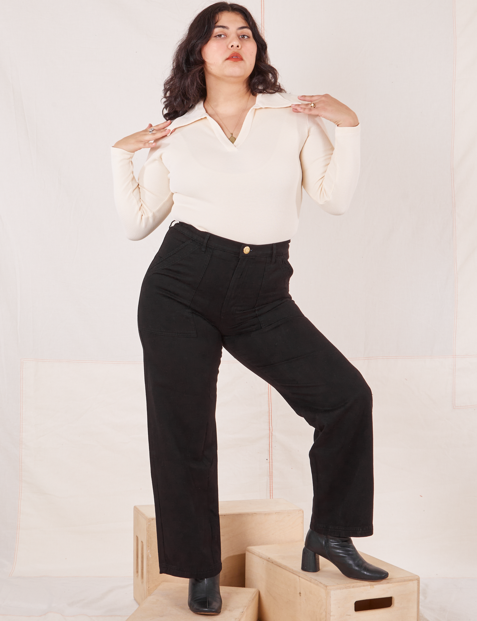 Melanie is 5&#39;6&quot; and wearing M Organic Work Pants in Basic Black paired with vintage off-white Long Sleeve Fisherman Polo