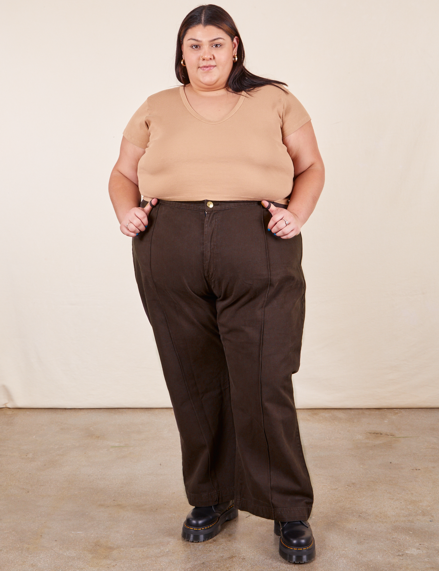 Sarita is 5&#39;7&quot; and wearing 3XL Western Pants in Espresso Brown paired with a tan V-Neck Tee