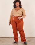Morgan is 5'5" and wearing 3XL Work Pants in Burnt Terracotta paired with tan Wrap Top