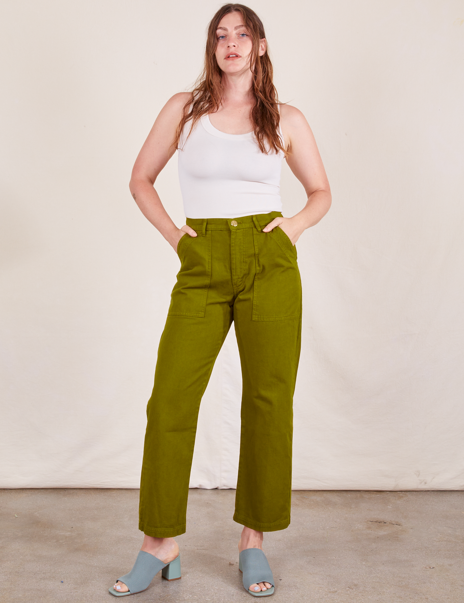 Allison is 5&#39;10&quot; and wearing S Work Pants in Olive Green paired with vintage off-white Tank Top