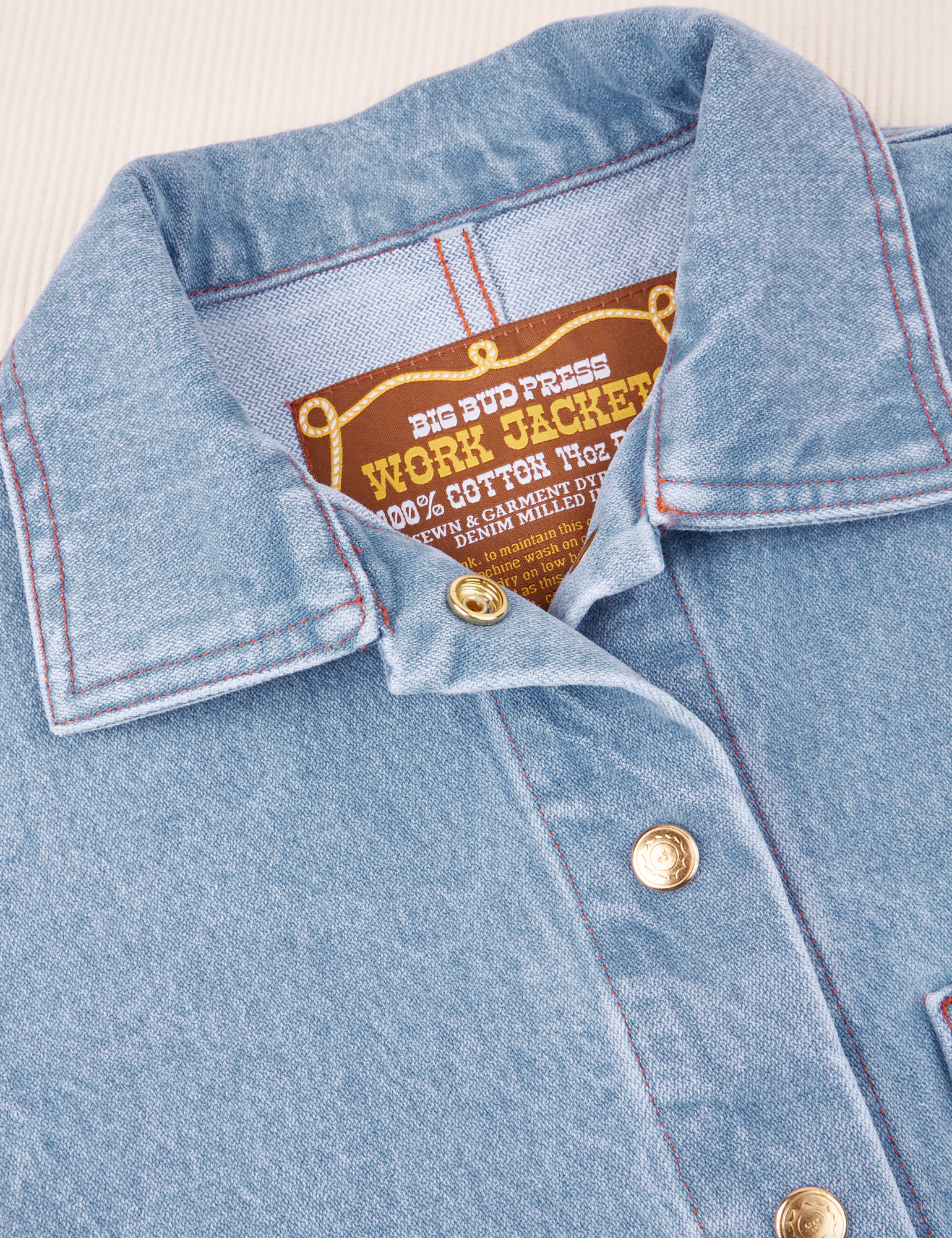 Indigo Denim Work Jacket in Light Wash collar and brass button close up