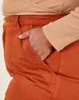 Work Pants in Burnt Terracotta side view with hand in front pocket on Morgan