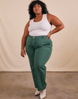 Morgan is 5'5" and wearing 3XL Work Pants in Dark Emerald Green paired with vintage off-white Tank Top