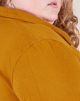 Shoulder close up of Long Sleeve Fisherman Polo in Spicy Mustard worn by Catie