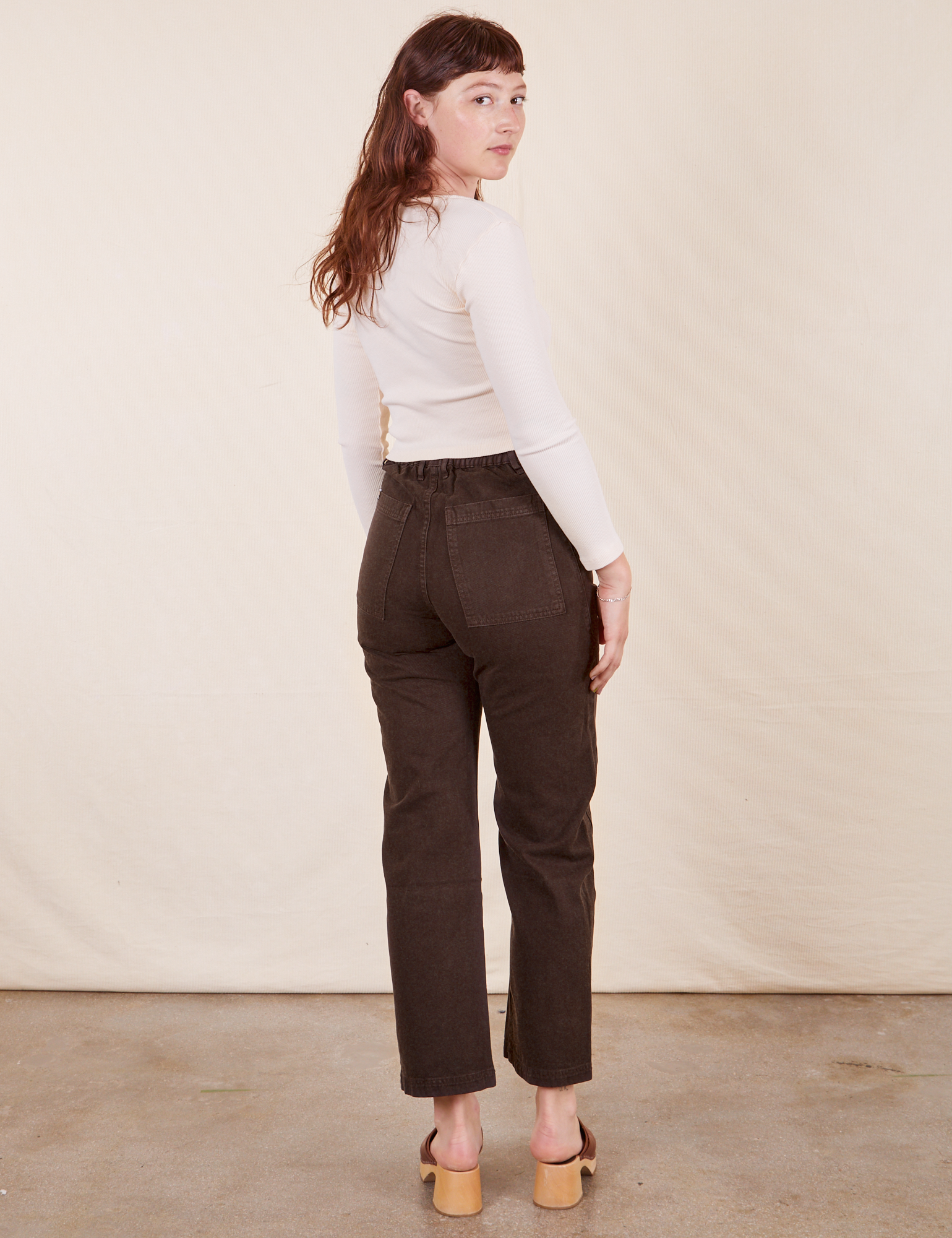 Back view of Work Pants in Espresso Brown and vintage off-white Long Sleeve V-Neck Tee on Alex