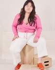 Wrap Top in Bubblegum Pink on Ashley wearing vintage tee off-white Western Pants sitting on wooden crate