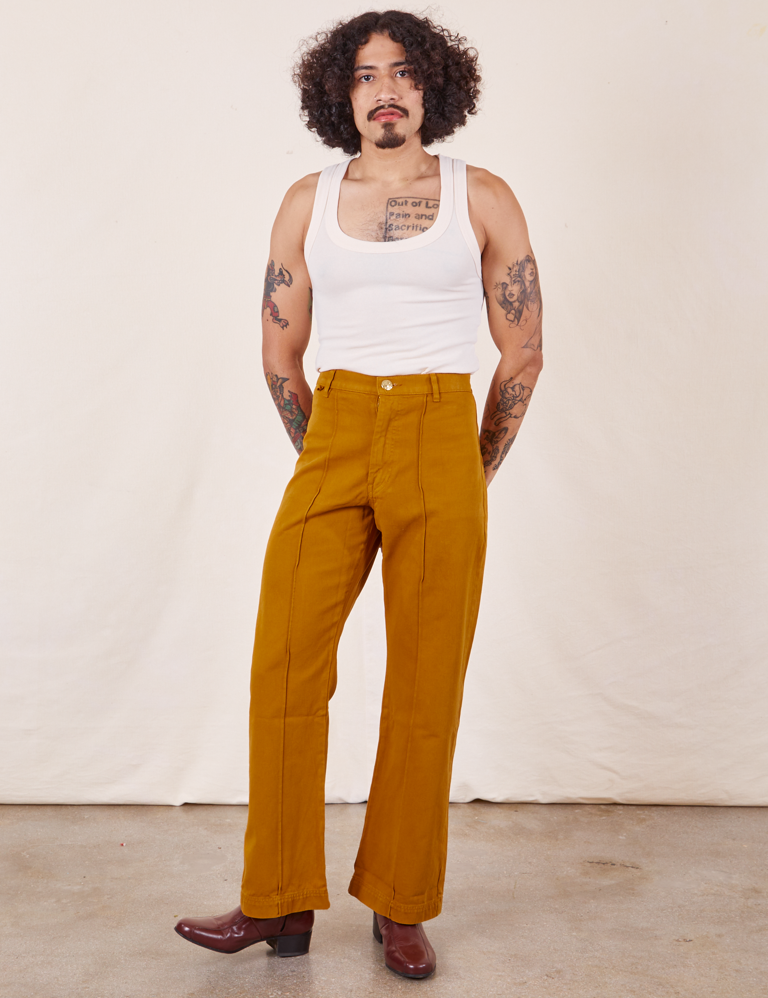 Jesse is 5&#39;8&quot; and wearing XS Western Pants in Spicy Mustard paired with vintage off-white Tank Top