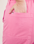 Work Pants in Bubblegum Pink back pocket close up on Faye with hand in pocket