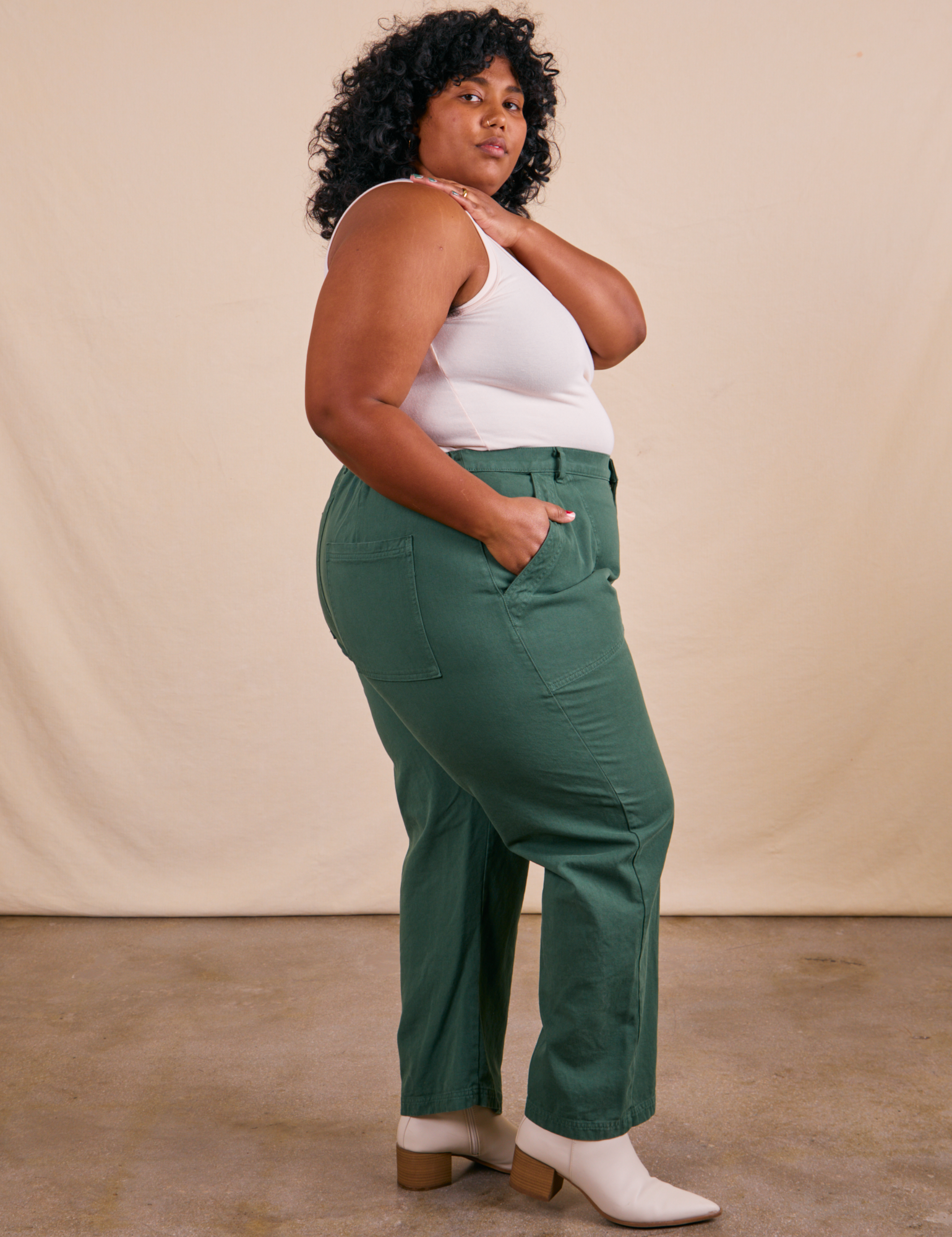 Side view of Work Pants in Dark Emerald Green and vintage off-white Tank Top on Morgan