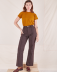 Alex is wearing P Organic Vintage Tee in Spicy Mustard paired with espresso brown Western Pants
