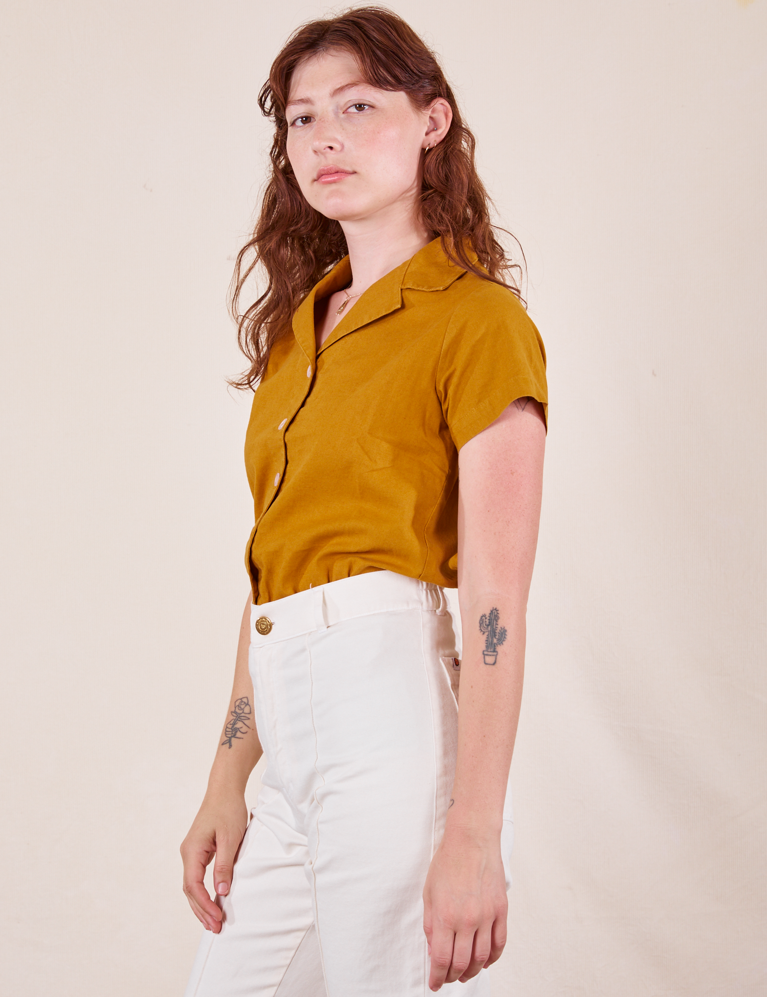 Side view of Pantry Button-Up in Spicy Mustard and vintage off-white Western Pants worn by Alex
