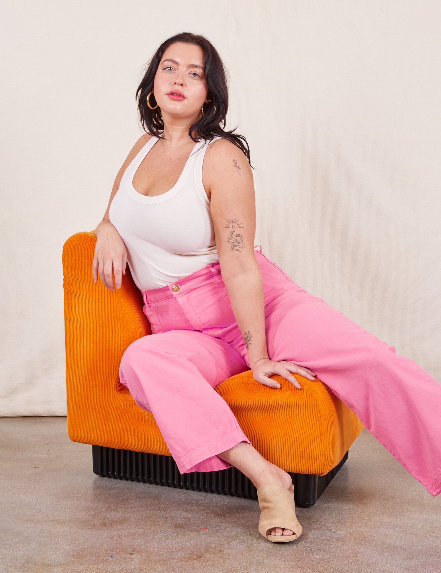Work Pants in Bubblegum Pink on Faye wearing Tank Top in vintage tee off-white sitting in orange chair