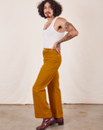 Side view of Western Pants in Spicy Mustard and vintage off-white Tank Top on Jesse