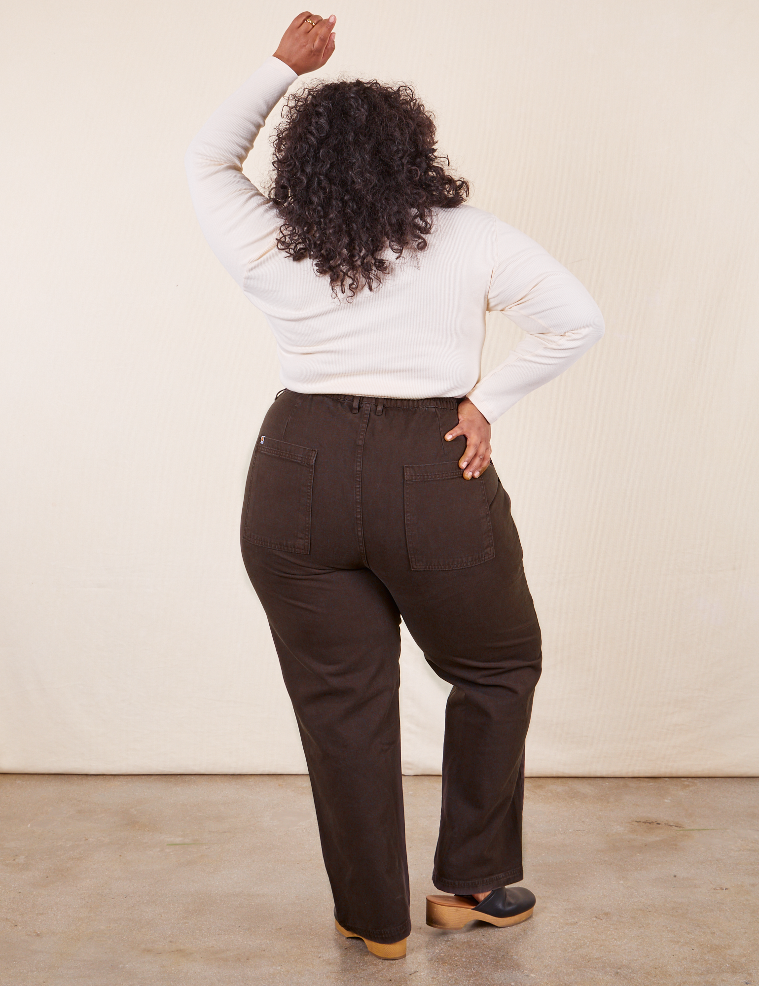 Back view of Work Pants in Espresso Brown and vintage off-white Long Sleeve V-Neck Tee on Morgan