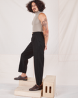 Side view of Heritage Trousers in Basic Black and khaki grey Sleeveless Turtleneck worn by Jesse