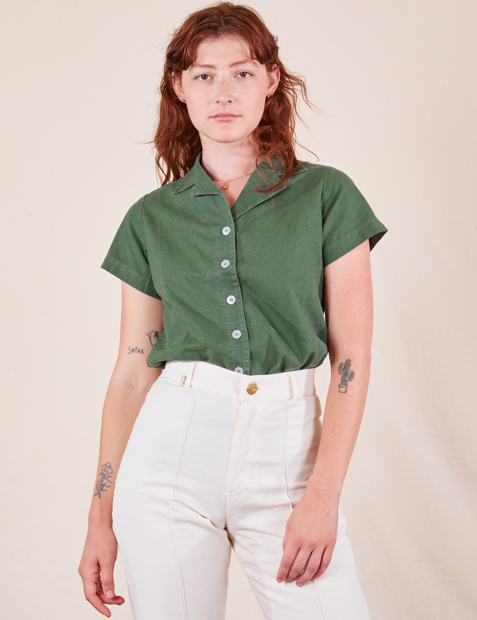 Alex is wearing P Pantry Button-Up in Dark Emerald Green tucked into vintage tee off-white Western Pants