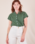 Alex is wearing P Pantry Button-Up in Dark Emerald Green tucked into vintage tee off-white Western Pants