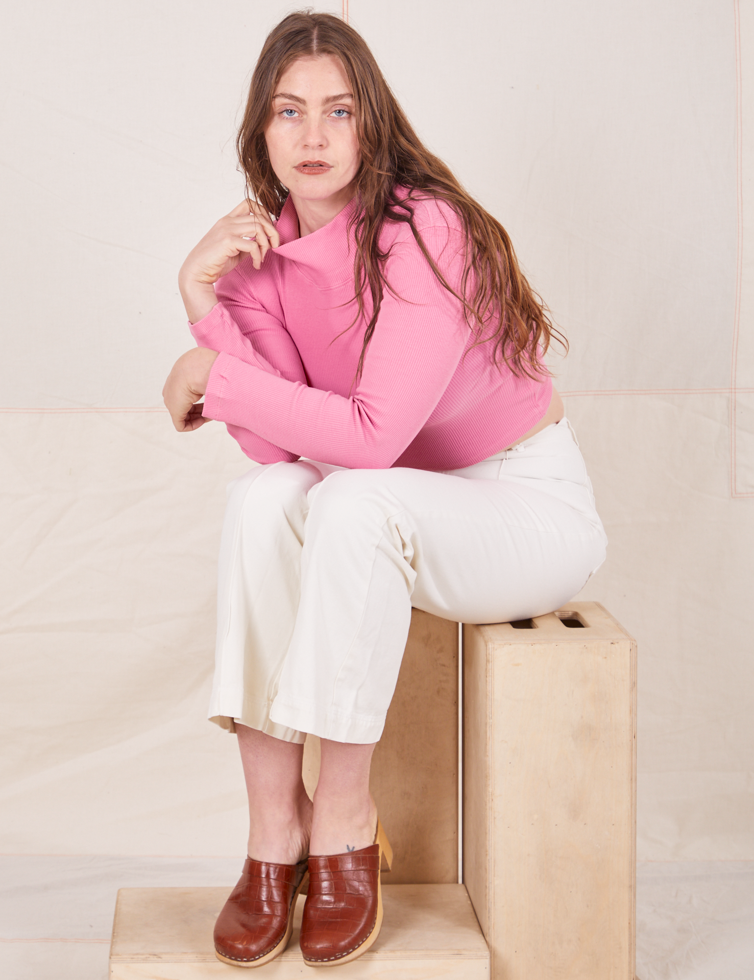 Essential Turtleneck in Bubblegum Pink on Allison wearing vintage tee off-white Western Pants sitting on wooden crates