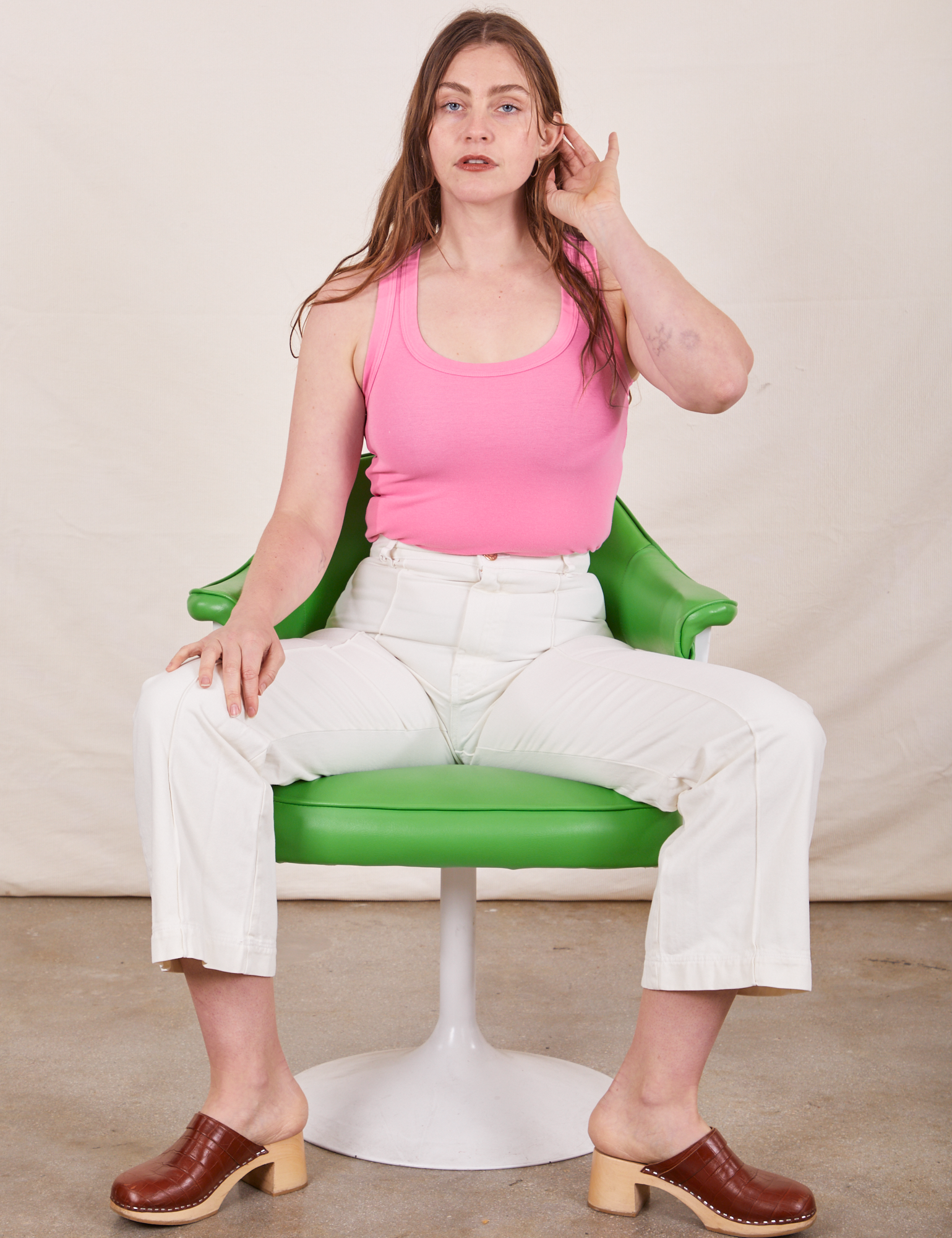 Tank Top in Bubblegum Pink on Allison wearing vintage tee off-white Western Pants sitting in green chair